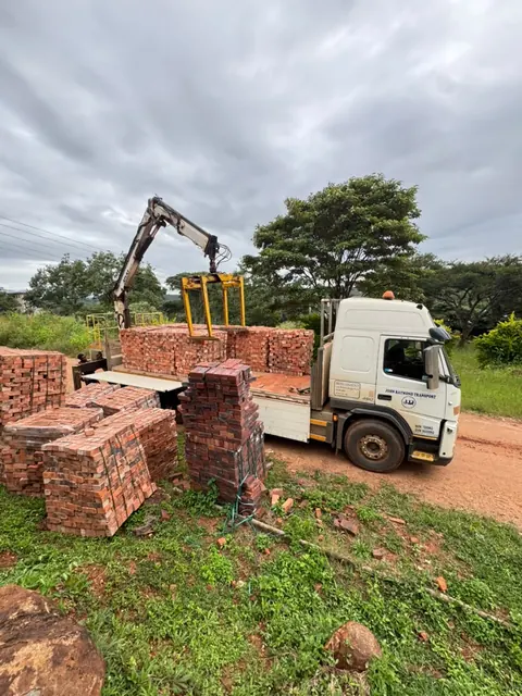 Tipper truck being loaded with bricks on site during a Harare brick delivery